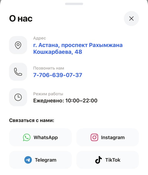 Окно «О нас» в витрине цветочного магазина: адрес в Астане, телефон, часы работы и соцсети